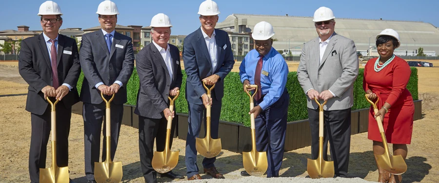 Groundbreaking ceremony with gold shovels and white hard hats