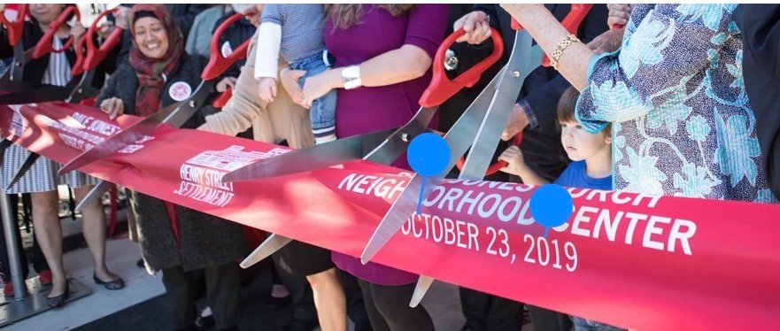 Community ribbon-cutting ceremony with oversized scissors